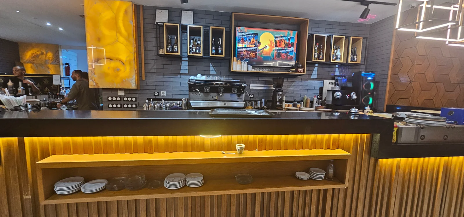 Le comptoir de Dolce Seven à Tétouan, machine à café et façade en bois éclairée